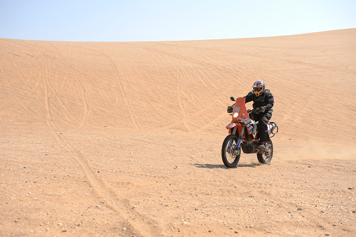 Swakopmund, Namibia.  31 August, 2011.  A KTM 660 Adventure motorbike is rides on a stretch of sand dunes south of Swakopmund