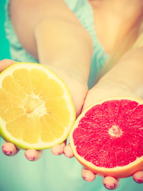 istock Halfs of yellow red grapefruit citrus fruit in human hands 1170282205