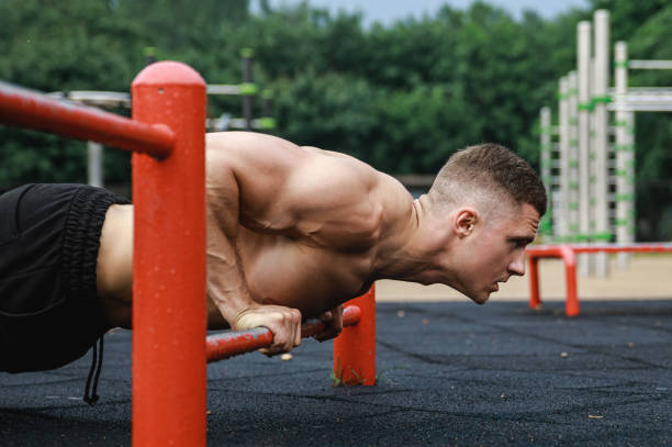 Muscular man during his workout on the street Young and muscular man during his workout on the street chest dip on athletic workout stock pictures, royalty-free photos & images