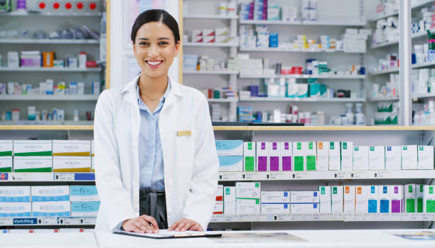 There's sure to be a treatment around here for you Portrait of a young pharmacist writing notes while working in a chemist pharmacist stock pictures, royalty-free photos & images