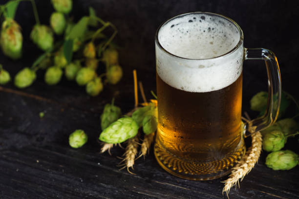 istock Beer mug on dark background with green hops and space for text 1170288046