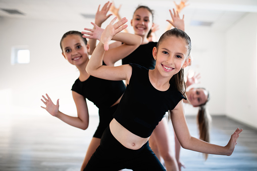 Grupo de niños felices en forma haciendo ejercicio de ballet en estudio juntos photo
