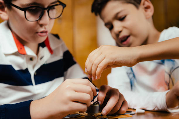 School boys making a windmill model for a school project. Generic unbranded toy.
