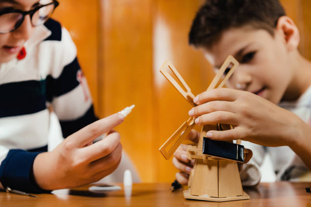 Kids playing, making a solar windmill model. Generic unbranded toy.