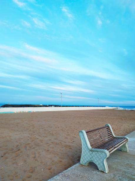 istock One bench near the sandy shore against a beautiful sky 1170292061