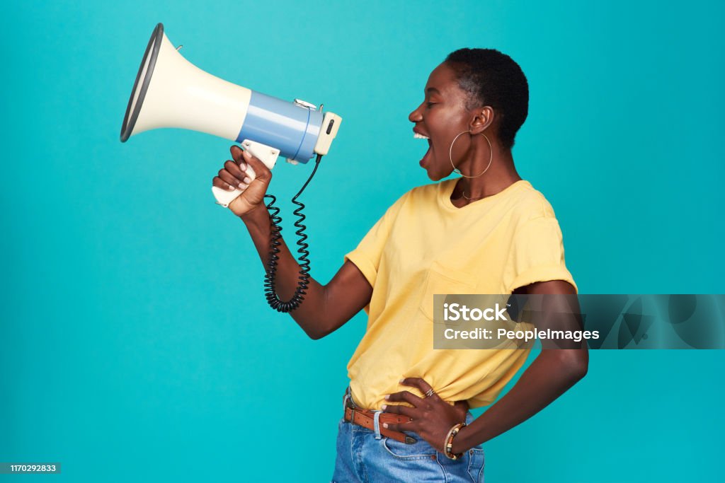 Nobody else has your voice. Use it Studio shot of a young woman using a megaphone against a turquoise background Megaphone Stock Photo
