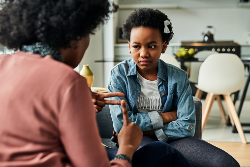 Cropped shot of a young girl looking upset while being scolded by her mother