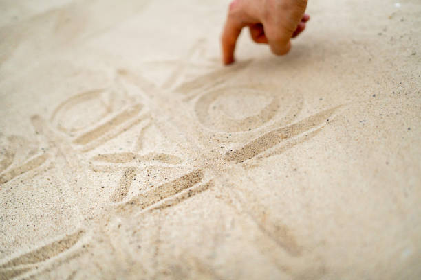 istock hand drawing tic tac toe playing on the sand in the summer beach 1170296092