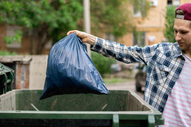 istock male dumping waste package into a big trash bin container 1170296180