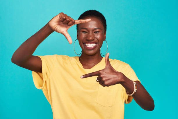 Change your perspective change your outcome Studio shot of a confident young woman making a finger frame of her face against a turquoise background hand cropping photos stock pictures, royalty-free photos & images