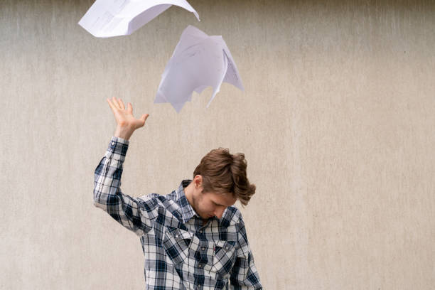 jeune homme stressé jeter des fichiers de papier froissé dans l'air, concept de liberté - paper document flying throwing photos et images de collection