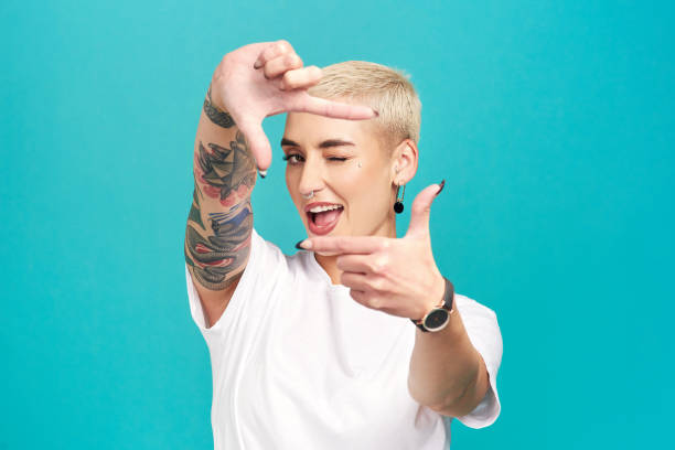 In a world of constant, change your perspective Studio shot of a confident young woman making a finger frame of her face against a turquoise background hand cropping photos stock pictures, royalty-free photos & images