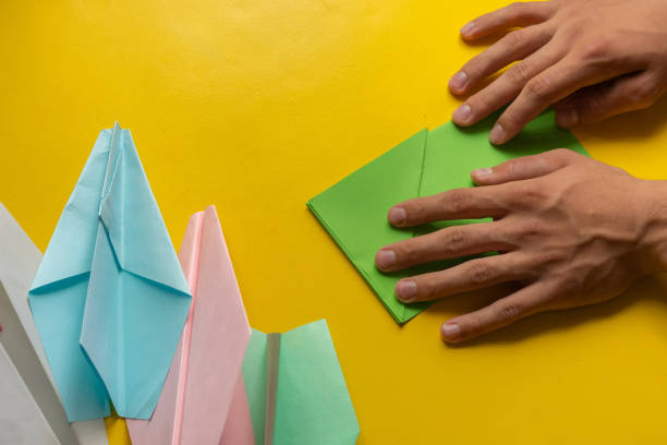 istock person hands making a origami color paper plane 1170296558