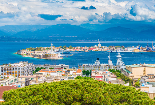 Beautiful panorama of Messina port with blue mountains in the background. It is written on the seawall in Latin \
