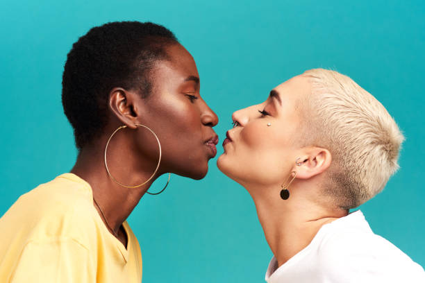 Best friends can be soulmates too Studio shot of two young women kissing against a turquoise background kissing stock pictures, royalty-free photos & images