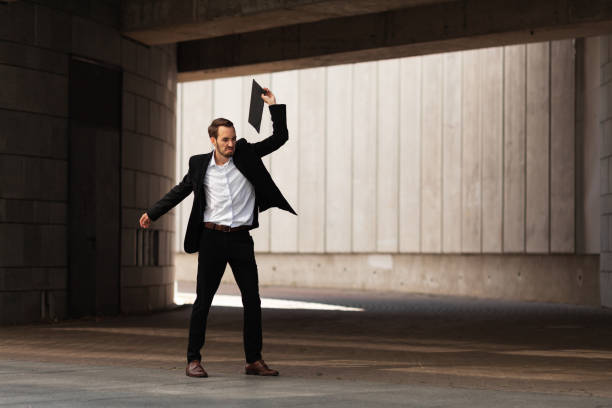 istock An upset and disappointed man in dark gateway, throws folder with resumes on floor, rage 1170301142