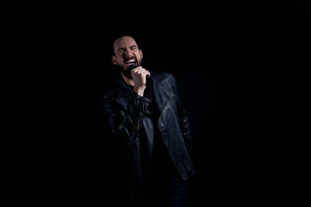 istock Handsome man singing with microphone and wearing leather jacket 1170301189