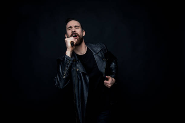 istock Handsome man singing with microphone and wearing leather jacket 1170301296