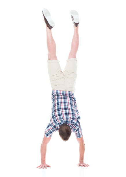 istock Handsome man in shirt and shorts is doing a handstand 1170303517