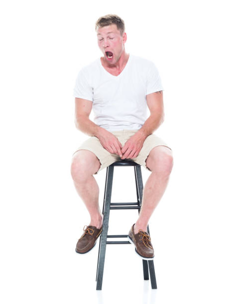 istock Handsome man in shirt and shorts is sitting on stool 1170303670