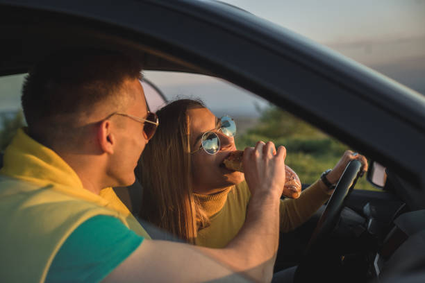 istock Boyfriend is feeding his girlfriend with a sandwich while she is driving a car 1170303934