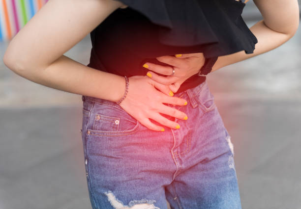 Young asian woman suffering pain on stomach while outdoors,chronic pain Young asian woman suffering pain on stomach while outdoors,chronic pain hernia photos stock pictures, royalty-free photos & images