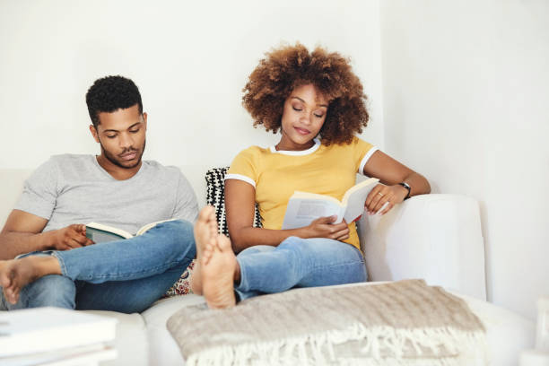 istock Young couple reading books while relaxing at home 1170306855