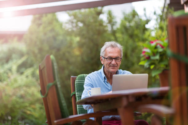 istock Senior man working on laptop in the garden 1170307873