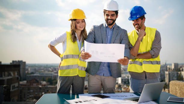 istock Team of architects and engineer in group on construciton site check documents and business workflow 1170307959