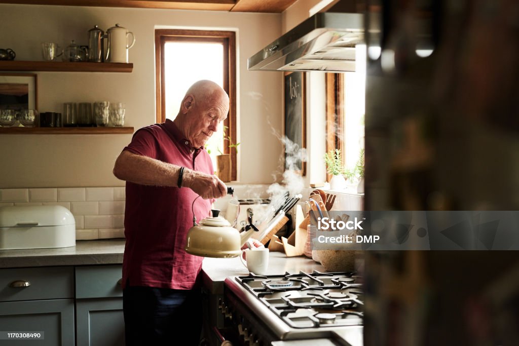 Coffee is just what I need Cropped shot of a senior man preparing a hot beverage at home Senior Adult Stock Photo