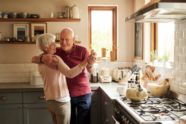 Love never grows old Cropped shot of a senior couple dancing in the kitchen at home dancing stock pictures, royalty-free photos & images