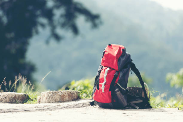 istock Hiking backpack travel gear on mountain. Items include hiking boots, cup, map, binoculars for travel destination and leisure in vacation. 1170309330