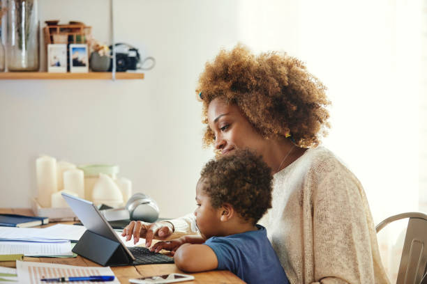 istock Smiling woman with son holding digital tablet 1170309516