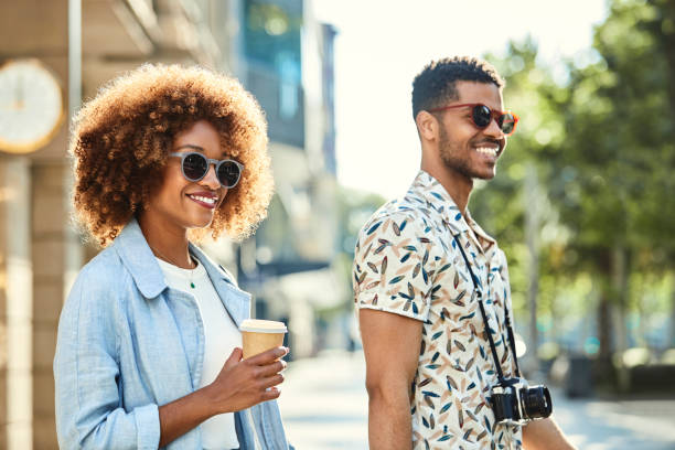 istock Smiling young couple walking on sidewalk in city 1170312612