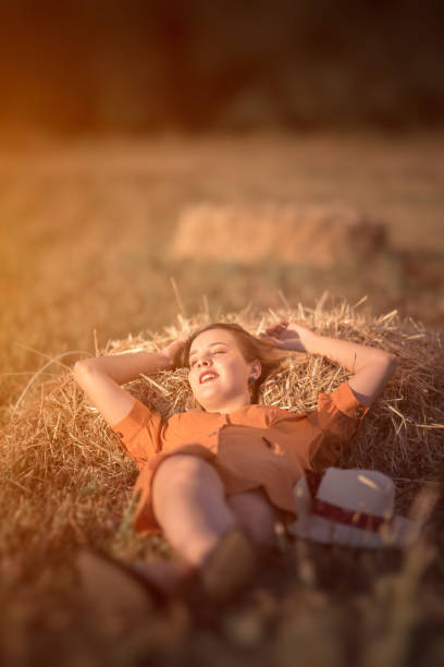 Young woman laying in hay
