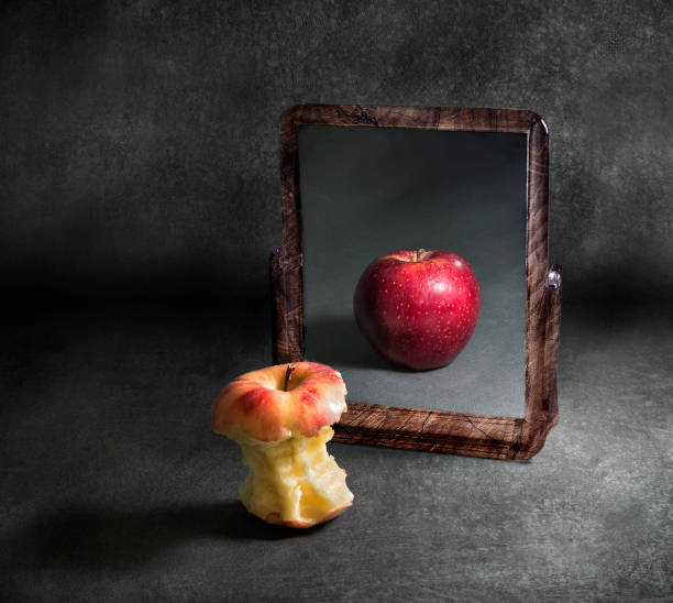 거울에 반사를보고 식욕 부진과 사과 - 착각 뉴스 사진 이미지