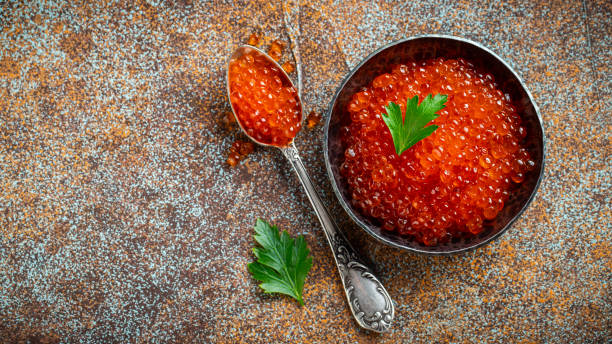 istock Delicious red caviar in black bowl on a dark concrete background. Top view with copy space. Flat lay 1170324853