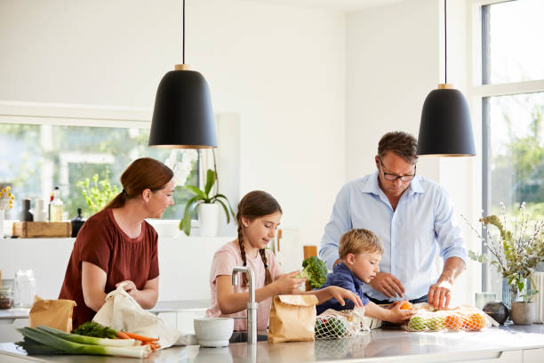 istock Curious children with parents unpacking groceries 1170328662