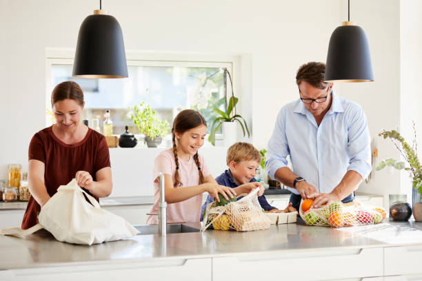 istock Family unpacking groceries at kitchen island 1170328730