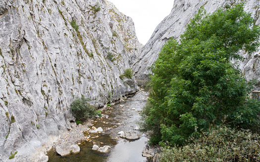 River and road with retaining walls on the edge, in a narrow gorge between stone mountains - Rio and road with retaining walls on the edge, in narrow gorge or gorge between stone mountains
