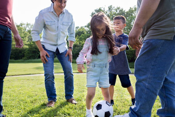 istock Brother physically guides sister while she tries to kick ball 1170329436