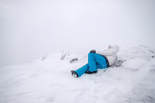 Man mountaineer wearing snow coat with relaxing on snowy peak