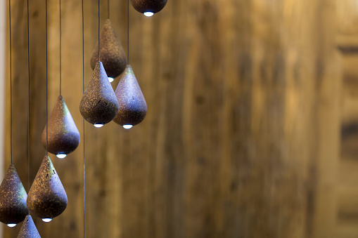 Modern chandelier, many small pendant lights in the form of drops of wood, eco style interior design.