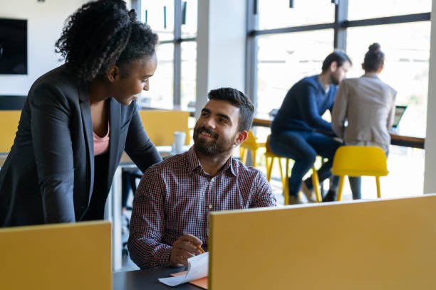 istock Diverse partners at a coworking office discussing something while man holds some documents both smiling at each other 1170332406