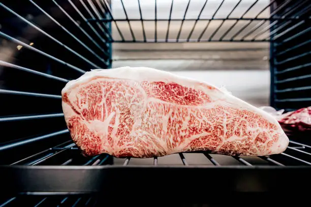 Premium Rare Sirloin Wagyu A5 beef with high-marbled texture inside refrigerator.