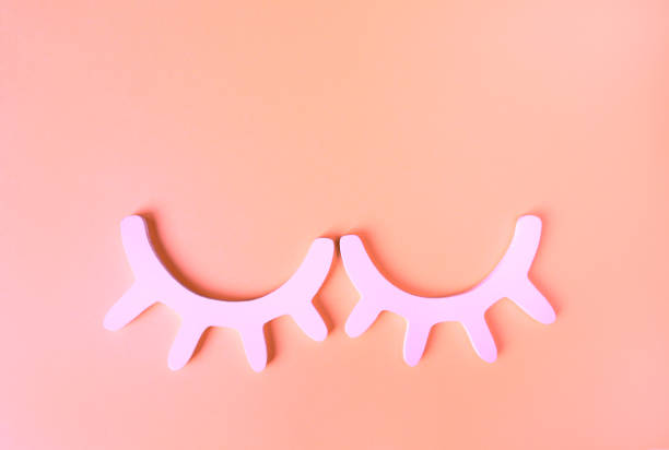 White wooden closed eyes with eyelashes in neon pink light on pastel background. Stylish wall decor. Top view, flat lay. Concept of vivid sweet dreams. Accessories for kids room. Minimal style White wooden closed eyes with eyelashes in neon pink light on pastel background. Stylish wall decor. Top view, flat lay. Concept of vivid sweet dreams. Accessories for kids room. Minimal style. neon bedroom stock pictures, royalty-free photos & images
