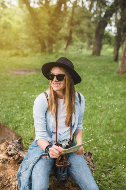 istock Happy female adventurer sitting and holding a map 1170335765