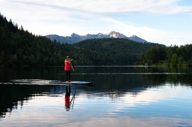istock Woman paddleboarding in lake against sky 1170340461