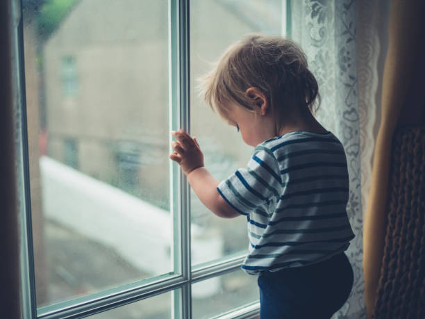 niño por ventana - baby1 fotografías e imágenes de stock