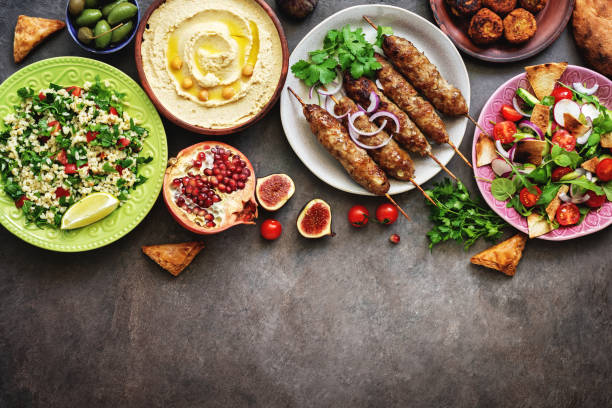istock Assorted Middle Eastern and arabic dishes on a dark rustic background. Hummus,tabbouleh, salad Fattoush,pita,meat kebab,falafel,baklava,pomegranate. Halal food.Top view, flat lay, copy space 1170346067
